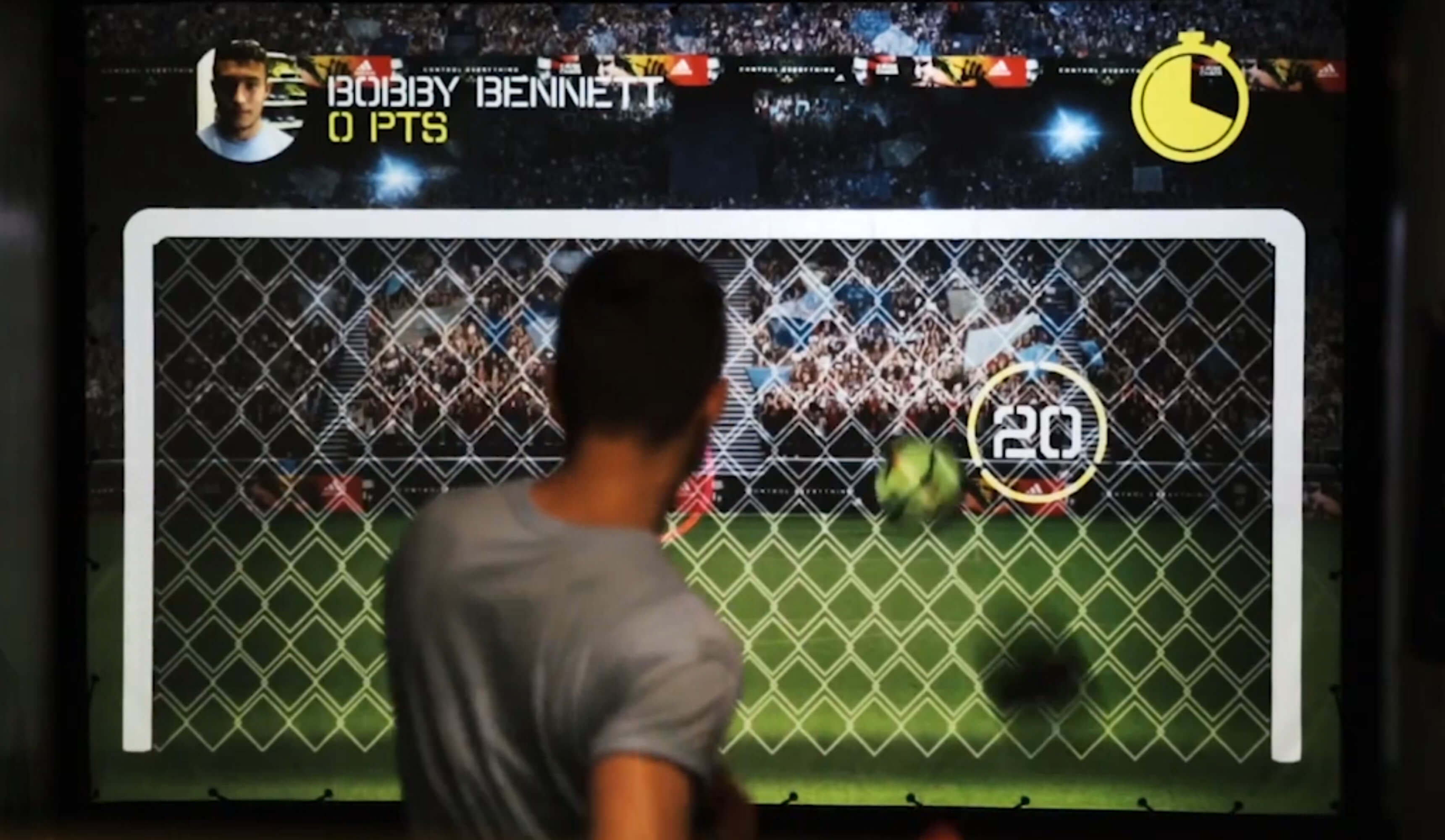 A player kicking the ball against the projected targets in the game area.